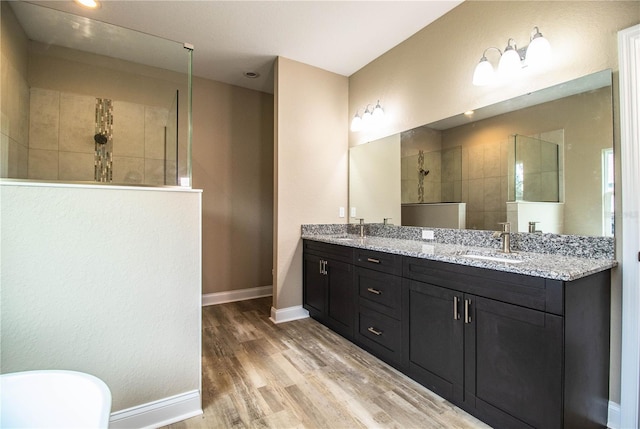 bathroom featuring a tile shower, hardwood / wood-style floors, and vanity