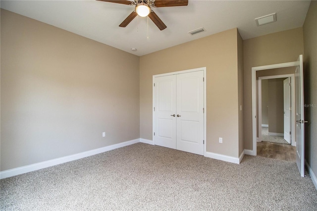 unfurnished bedroom featuring carpet flooring, ceiling fan, and a closet