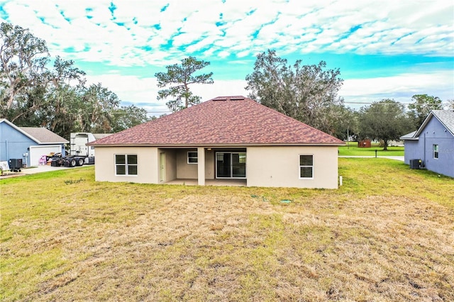 back of property featuring a lawn, cooling unit, and a patio