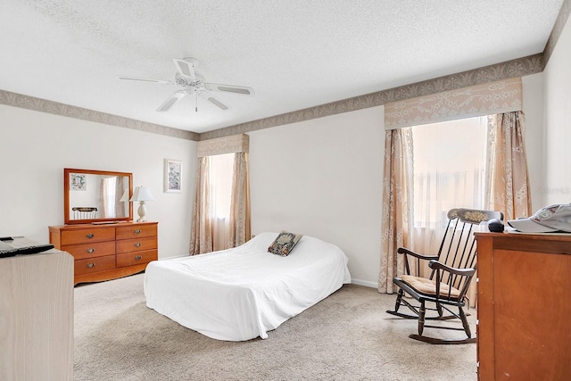 carpeted bedroom with ceiling fan and a textured ceiling