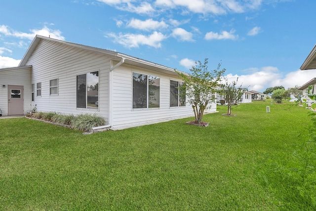 view of side of home with a yard