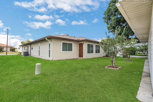 view of front of house with a front yard and central AC unit