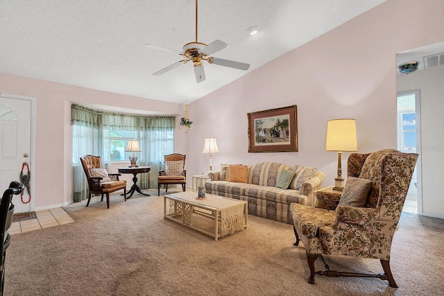 living room with ceiling fan, high vaulted ceiling, light carpet, and a textured ceiling