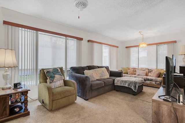 carpeted living room featuring plenty of natural light, a chandelier, and a textured ceiling