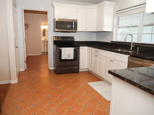 kitchen featuring appliances with stainless steel finishes, white cabinetry, sink, and light tile patterned floors