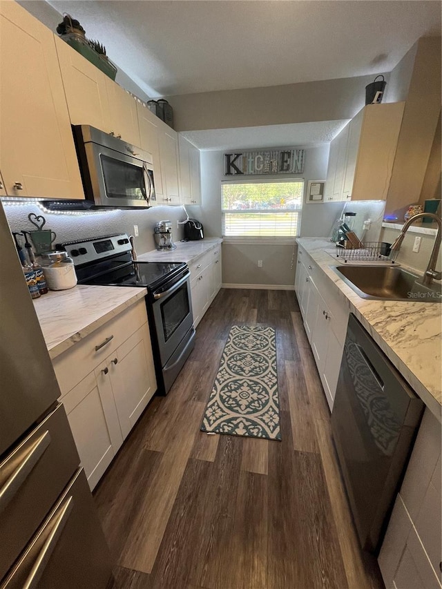 kitchen with white cabinetry, appliances with stainless steel finishes, sink, and dark hardwood / wood-style flooring