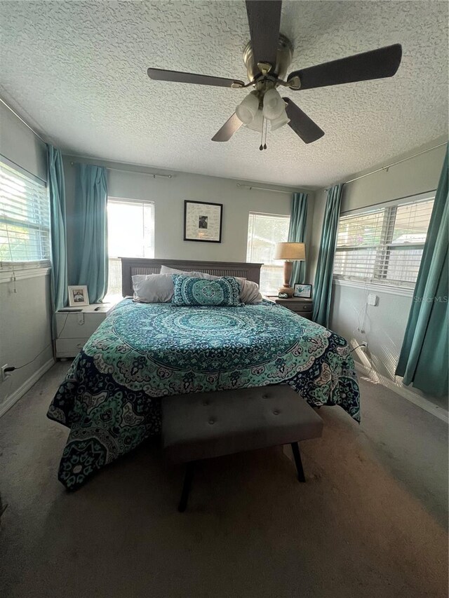 bedroom featuring ceiling fan, a textured ceiling, and carpet floors