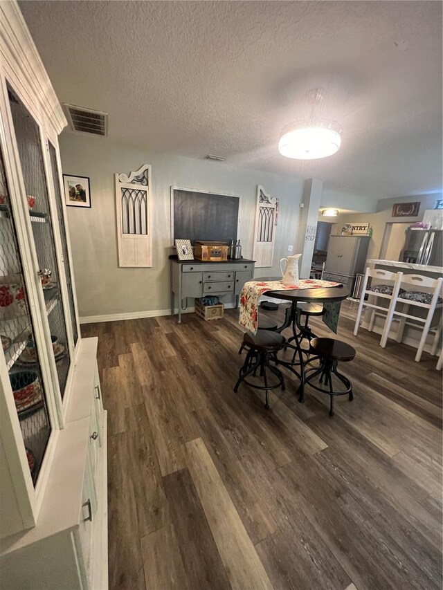 dining space featuring dark hardwood / wood-style floors and a textured ceiling