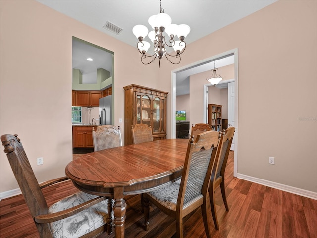 dining space with a chandelier and dark wood-type flooring