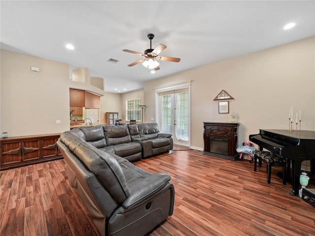 living room with ceiling fan, french doors, sink, and wood-type flooring