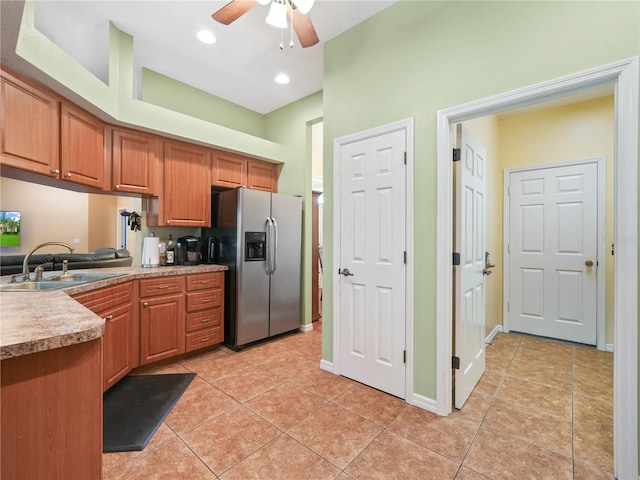 kitchen with sink, stainless steel refrigerator with ice dispenser, light tile floors, and ceiling fan