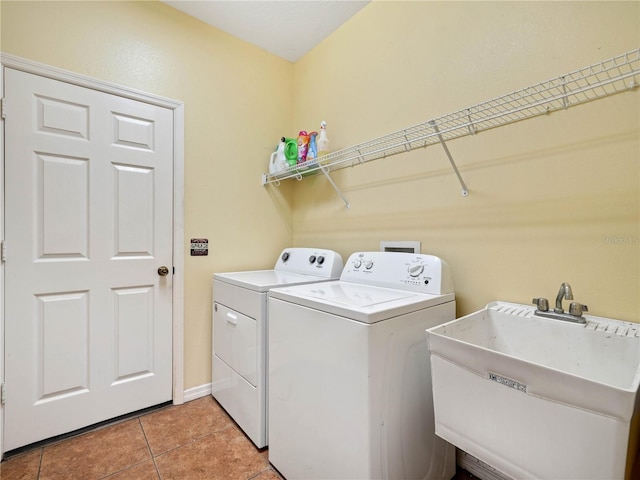 laundry area with sink, light tile floors, and washing machine and clothes dryer