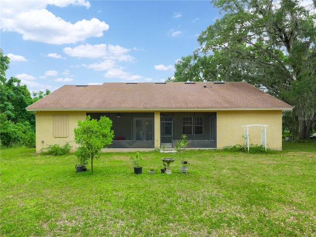 back of property featuring a sunroom and a lawn