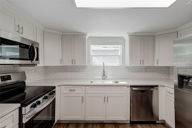 kitchen featuring appliances with stainless steel finishes, sink, dark wood-type flooring, and backsplash