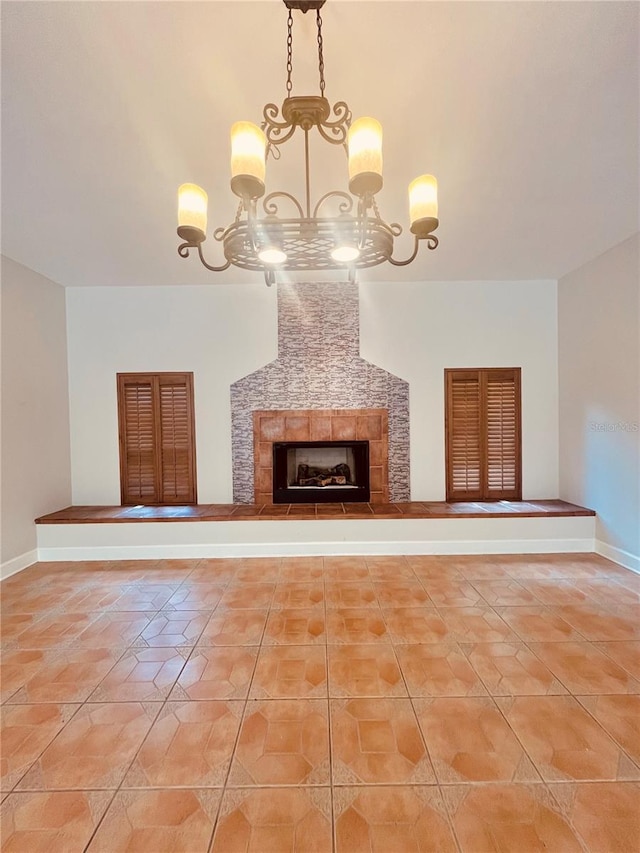 unfurnished living room featuring a notable chandelier, light tile flooring, and a tile fireplace