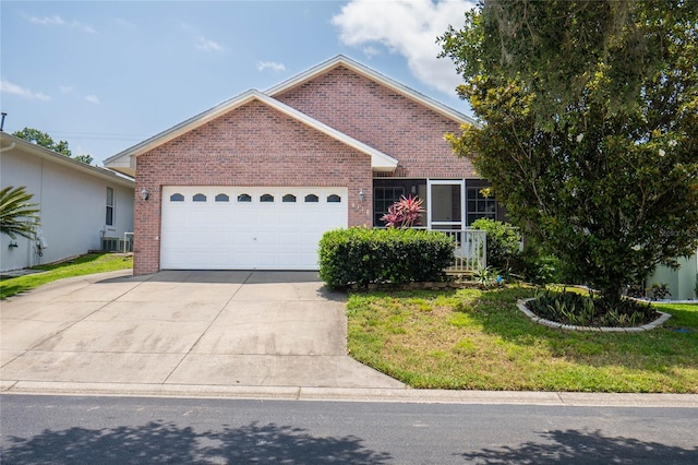 view of front of property featuring a garage, central AC, and a front lawn