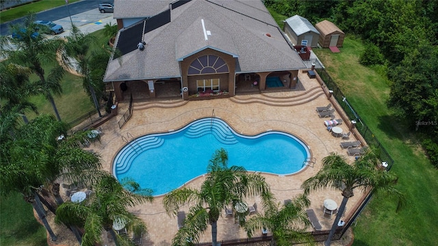 view of swimming pool featuring a patio, an outdoor structure, and a lawn