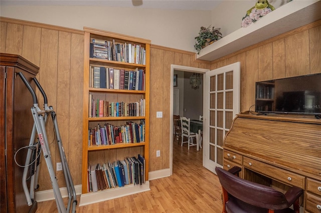 office with wood walls, light hardwood / wood-style flooring, and lofted ceiling