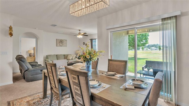 dining area featuring carpet floors and ceiling fan with notable chandelier