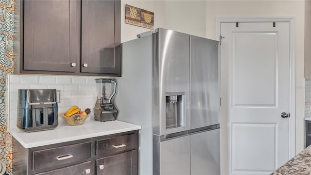 kitchen featuring dark brown cabinetry, backsplash, and stainless steel fridge with ice dispenser