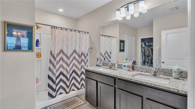 bathroom with oversized vanity, dual sinks, and tile floors