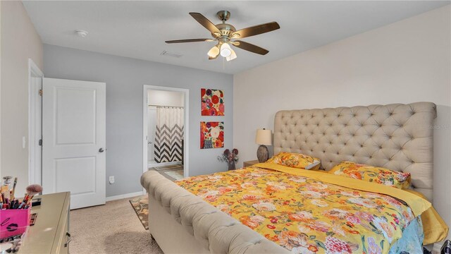 carpeted bedroom with connected bathroom and ceiling fan