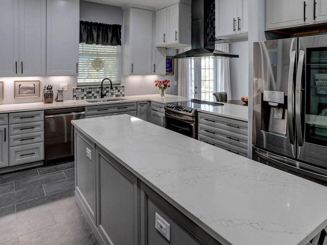 kitchen with stainless steel appliances, sink, wall chimney exhaust hood, and a wealth of natural light