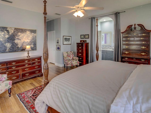 bedroom with ceiling fan, ensuite bathroom, and hardwood / wood-style flooring