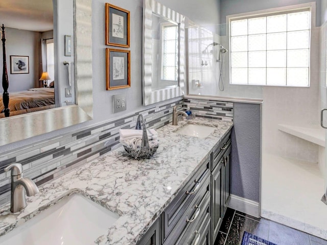 bathroom featuring tile floors, a healthy amount of sunlight, double vanity, and backsplash