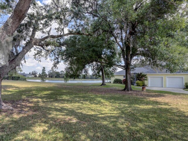 view of yard featuring a garage and a water view