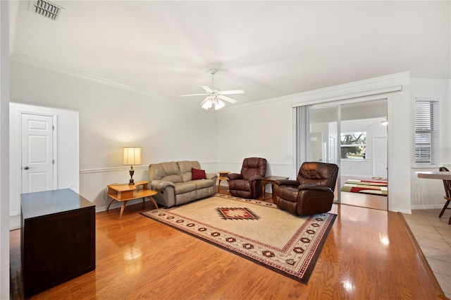 living room featuring crown molding, ceiling fan, and hardwood / wood-style flooring