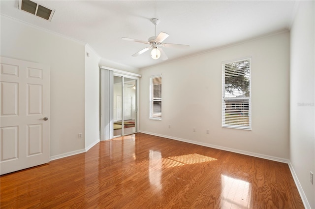 unfurnished bedroom with wood-type flooring, a closet, ceiling fan, and ornamental molding