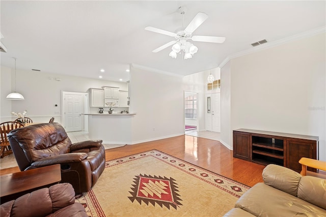 living room with ceiling fan, light wood-type flooring, and crown molding