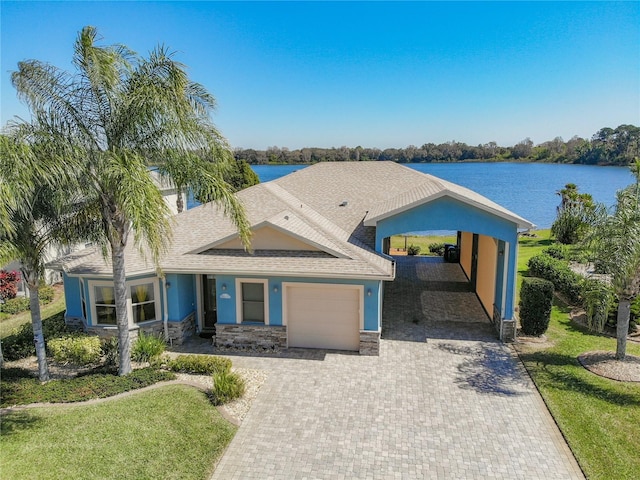 view of front facade featuring a front yard, a water view, and a carport