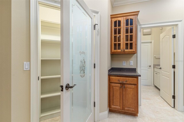 interior space with light tile patterned floors and ornamental molding