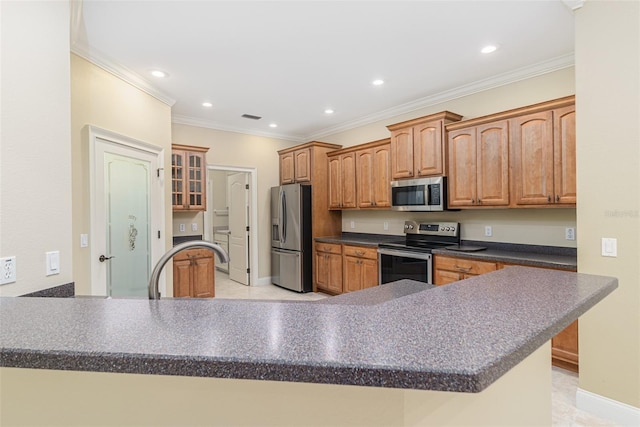 kitchen with kitchen peninsula, appliances with stainless steel finishes, crown molding, and sink