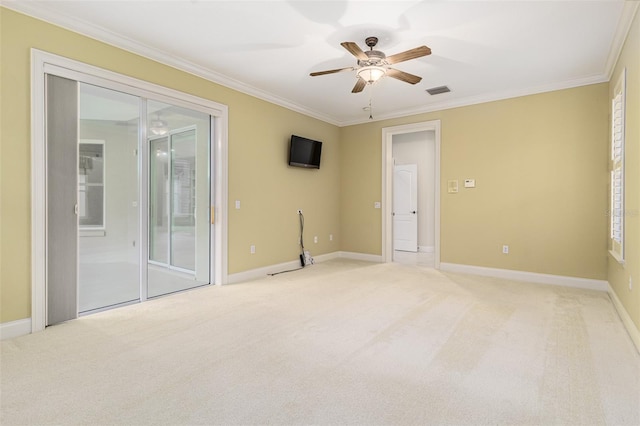 spare room featuring carpet, ceiling fan, ornamental molding, and a wealth of natural light