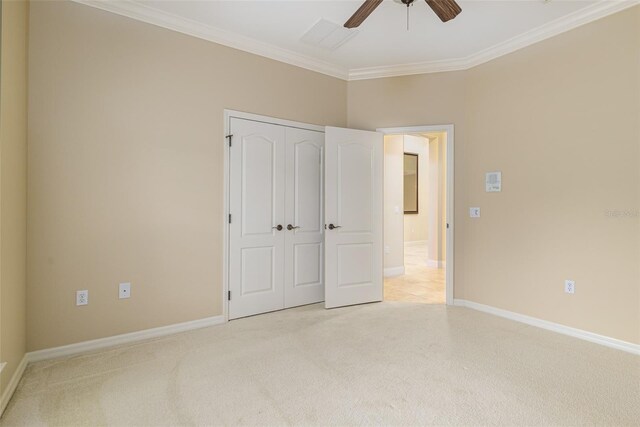 unfurnished bedroom with light carpet, a closet, ceiling fan, and crown molding