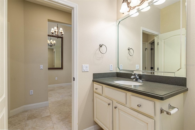 bathroom with a notable chandelier, vanity, and tile patterned floors