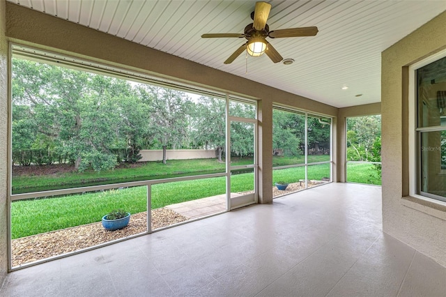 unfurnished sunroom featuring ceiling fan