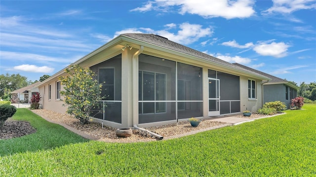 view of home's exterior featuring a lawn and a sunroom