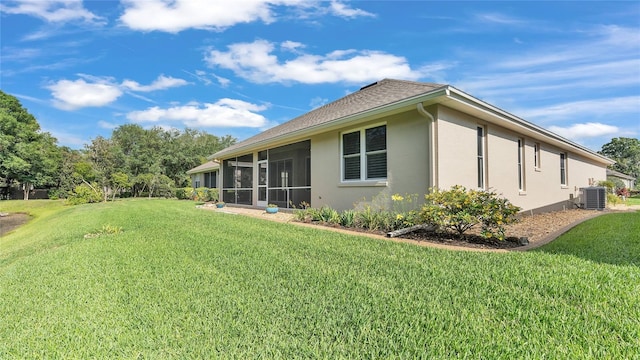 exterior space with a lawn, a sunroom, and cooling unit