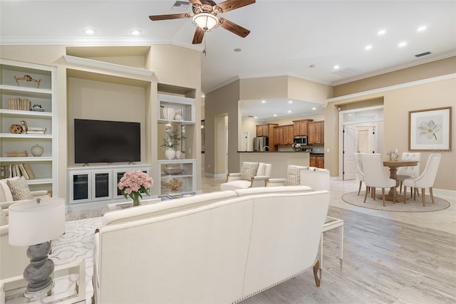 living room with crown molding, built in features, ceiling fan, and light hardwood / wood-style floors