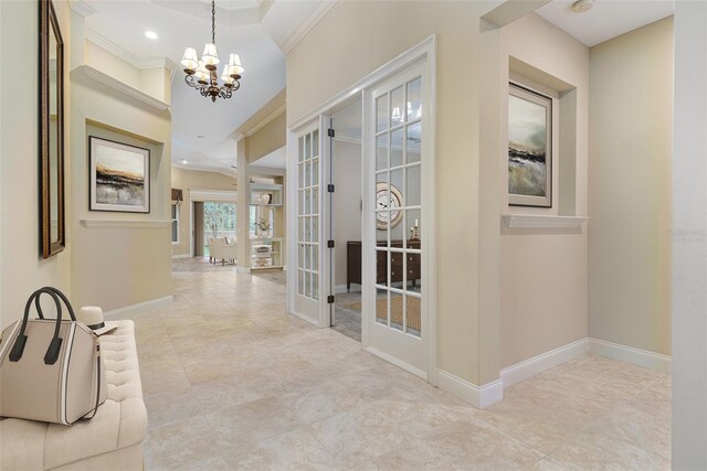 hallway with french doors, an inviting chandelier, and ornamental molding