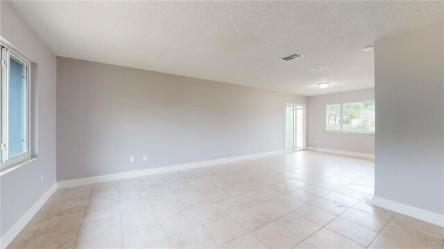 tiled spare room with a textured ceiling