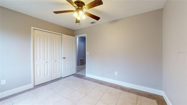 unfurnished bedroom featuring a closet, ceiling fan, and light tile floors