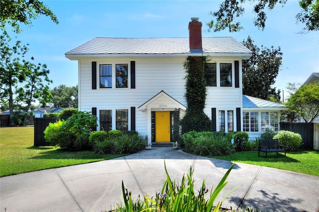 colonial inspired home featuring a front lawn