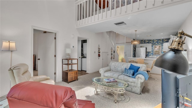 carpeted living room with stacked washer and clothes dryer and a high ceiling