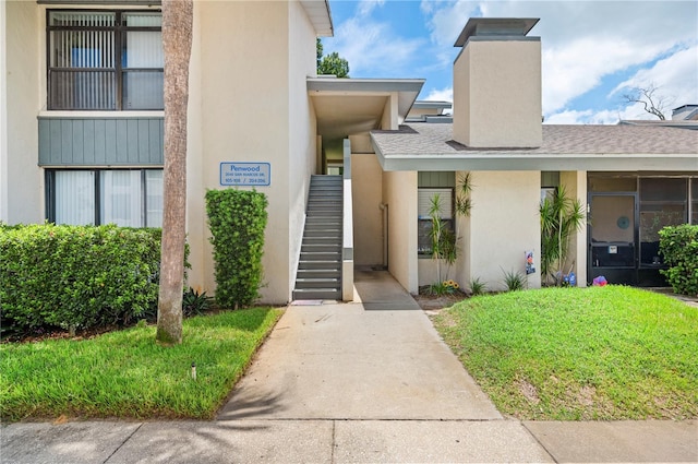 doorway to property with a lawn