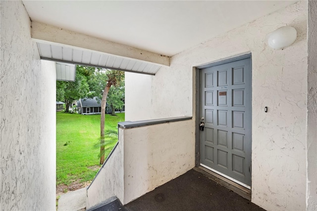 doorway to property with a lawn